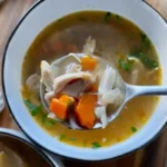 Homemade chicken drumstick soup with bone-in drumsticks and veggies in Dutch oven